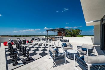 An outdoor patio with chess pieces and lounge chairs